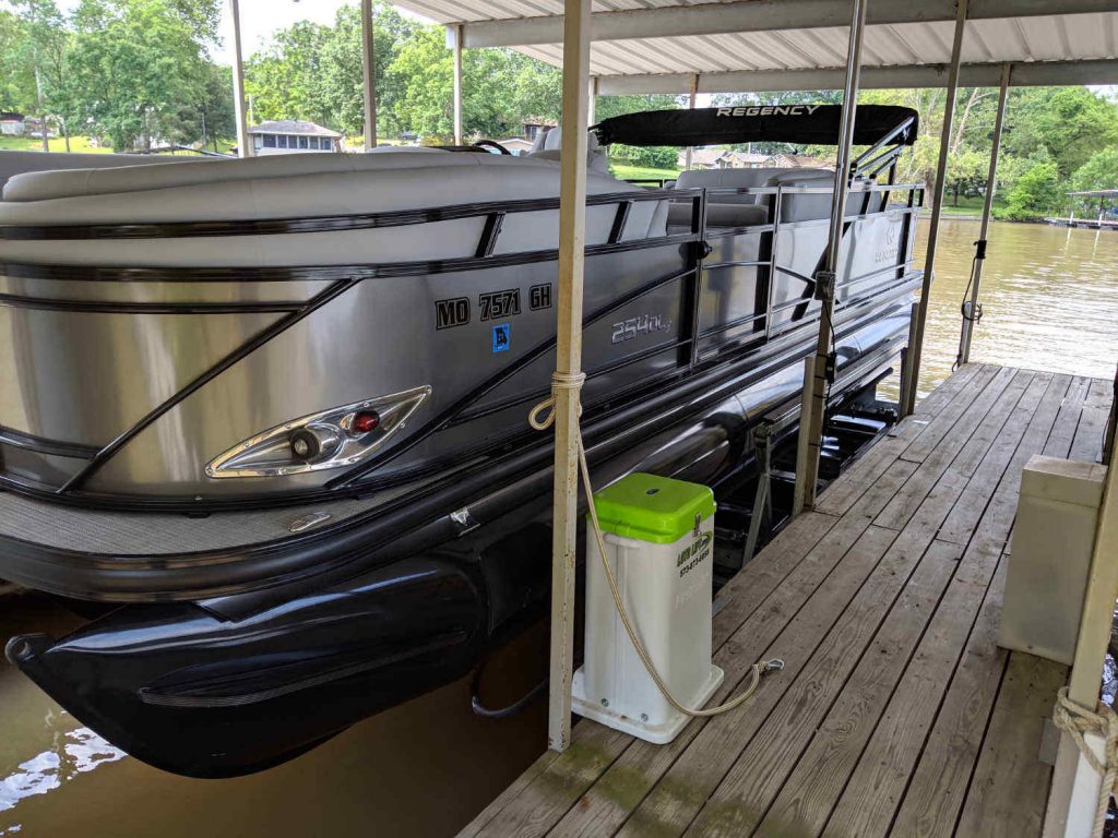Regency pontoon stored dry on a LOTO Lift LT Model side-mount boat lift in a covered Lake of the Ozarks slip.