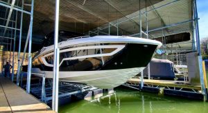 Nice lake cruiser raised out of the water on a boat dock lift.