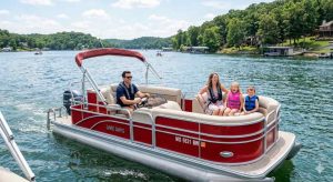 A red pontoon boat with a family on Lake of the Ozarks, highlighting the type of vessel that requires specialized pontoon boat lifts.