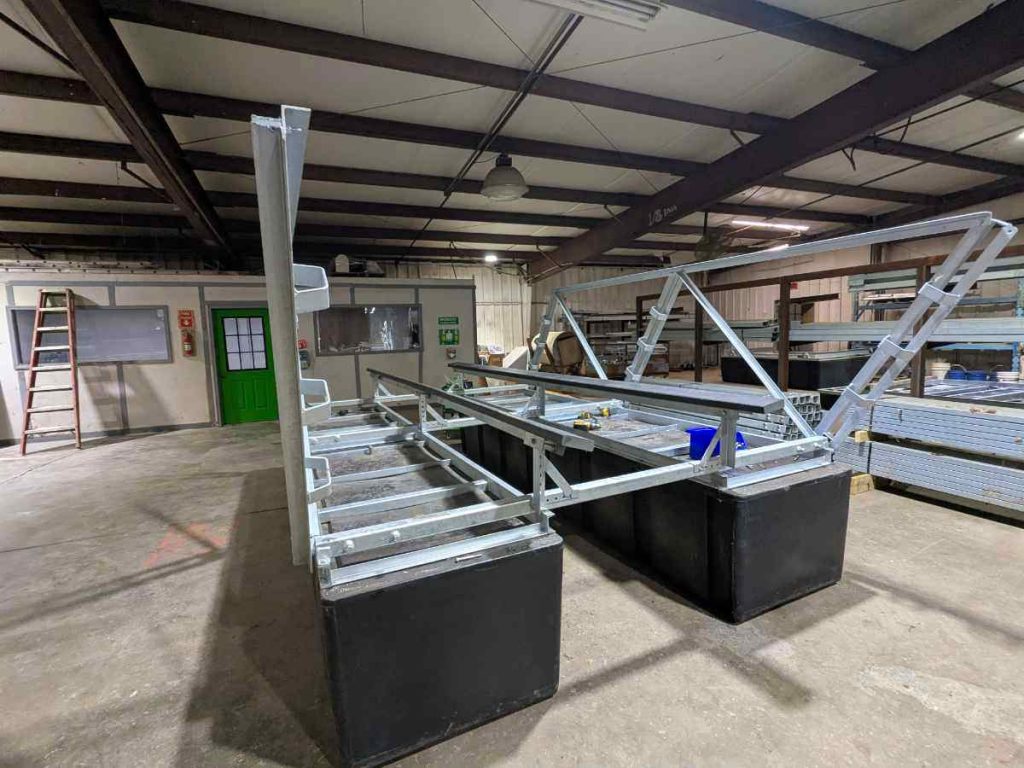 TR Model "The Rock" forward lifting boat lift under construction in our Lake of the Ozarks shop, showing the heavy-duty galvanized steel frame and parallel black poly tanks. Designed for durability with a lifetime warranty on the roto-molded poly tanks and 10-year frame warranty. Keeps steel out of the water to reduce electrolysis and growth while delivering reliable performance at a real-world price. LOTO Lift – 573-873-6058.