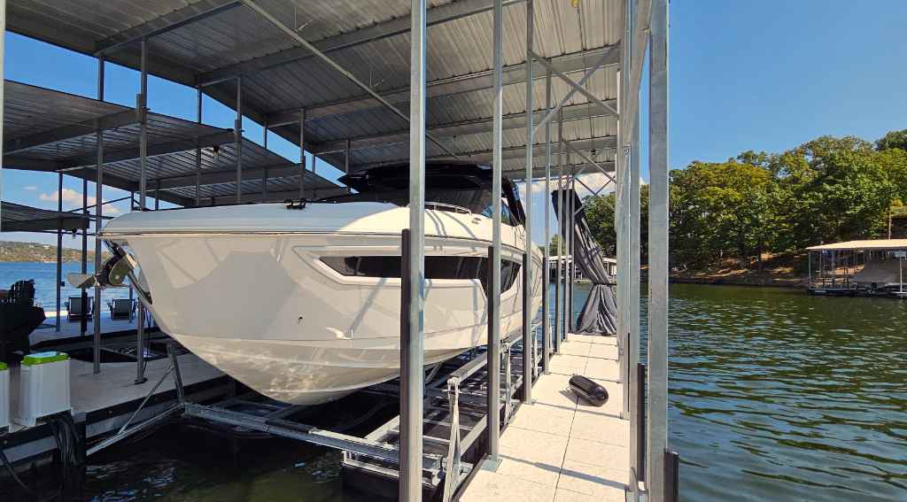 Professionally installed pneumatic floating boat lift with Captain's Choice control unit holding a white yacht at a Lake of the Ozarks dock in Camdenton, Missouri.