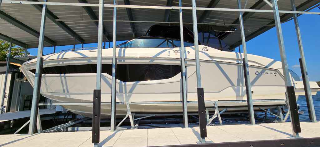 Pneumatic floating boat lift professionally installed holding a white motor yacht safely out of the water at a Lake of the Ozarks dock in Camdenton MO.