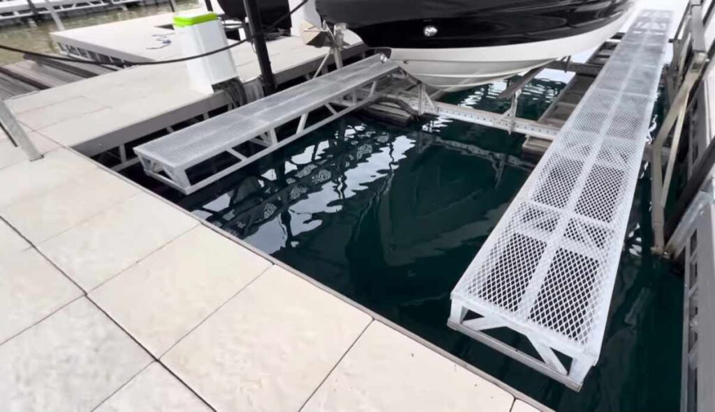 Port and starboard custom steel walkways on a LOTO Lift boat lift installation at Lake of the Ozarks, allowing full 360-degree safe access around the raised vessel.