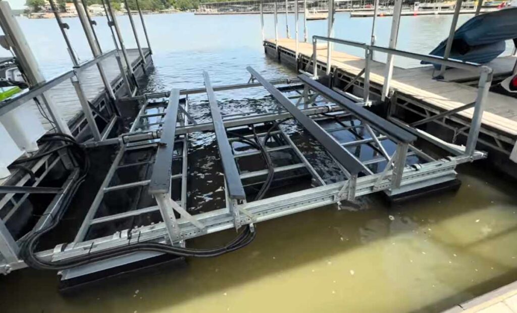A wide slip boat lift at Lake of the Ozarks with multi-row pneumatic tanks installed in a spacious dock slip, front view.