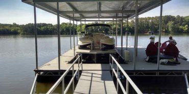 Pontoon boat on shallow water floating boat lift.